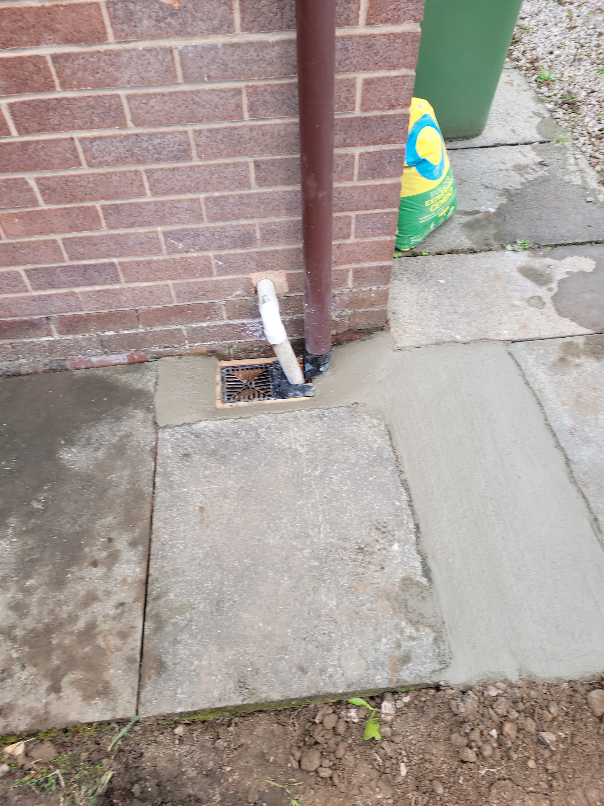 A finished gully and downpipe connection set in fresh mortar